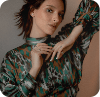 Fashion model in green patterned outfit posed by face